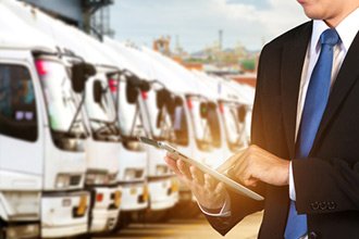 man using ipad in front of busses